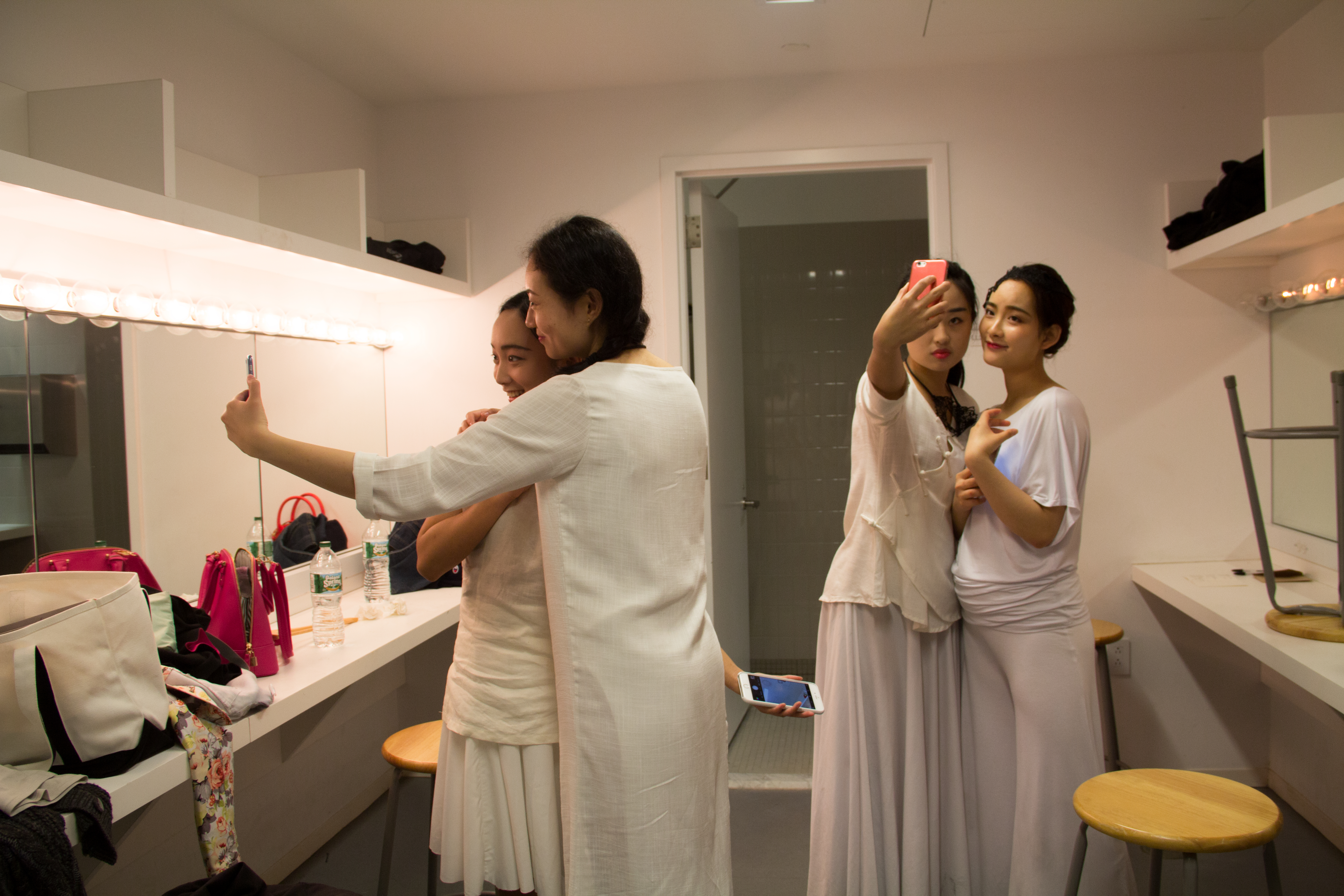 The actresses are taking selfies with their cellphones before the final performance.